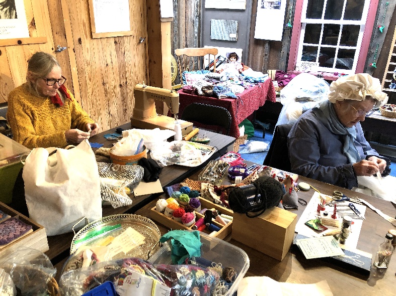 Volunteers knitting and mending clothes at the Cottage